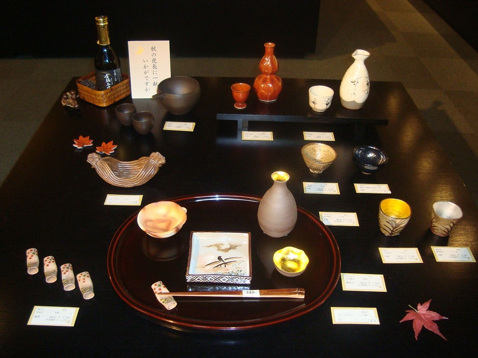 「秋の夜長に」の札を添え、日本酒の瓶と徳利、ぐい呑、紅葉を並べた秋の展示