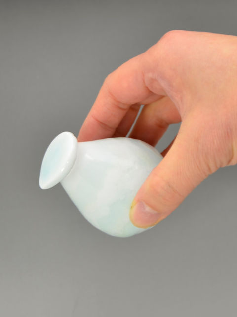 手に持ったしずく形の醤油さし、注ぎ口を前に傾けた様子