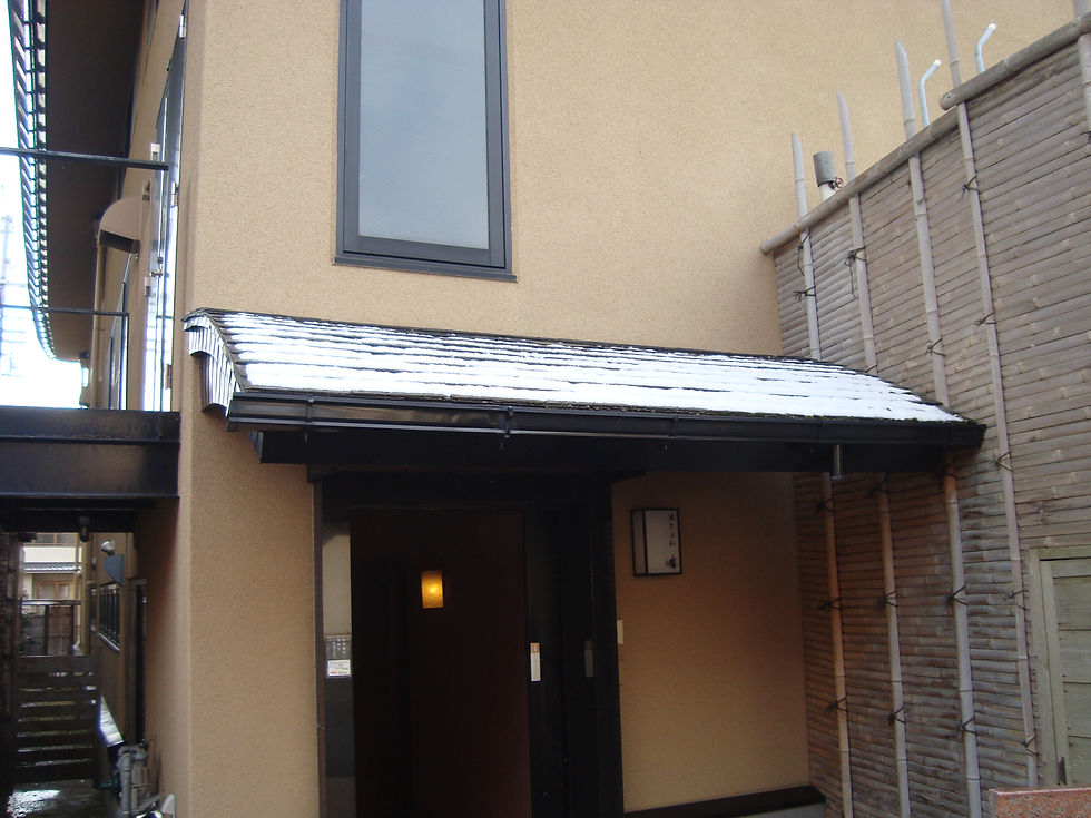 うっすらと雪が積もった庇のある、和風建物の玄関