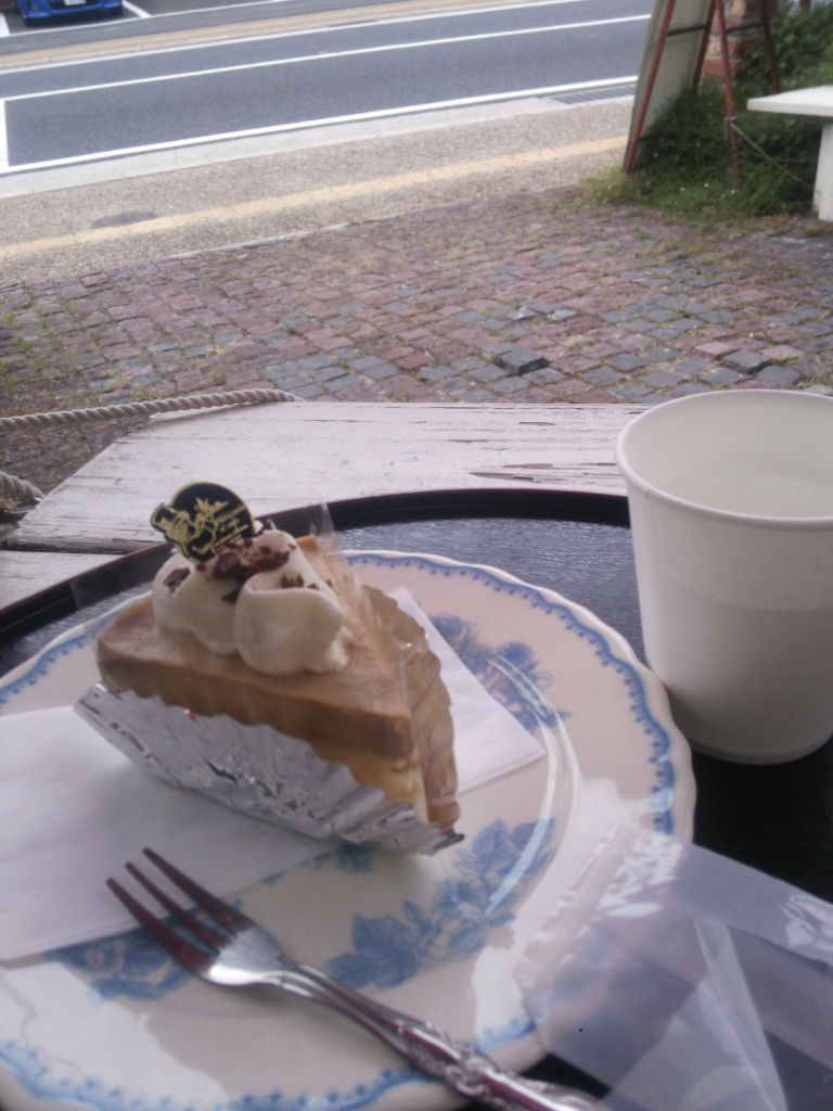 青い絵付けの皿にのせたケーキと紙コップ