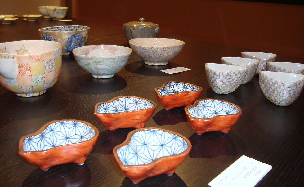 市松や網目、赤い花形の器が黒いテーブルに並ぶ内田さんの作品