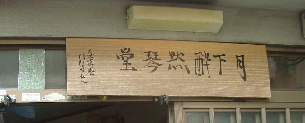 「月下酔琴堂」と墨書された木の看板(西岡義弘さんの工房の表札)