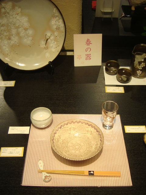 「春の器」の札が立つ展示棚に桜の大皿や蕎麦猪口、取り皿を並べた様子