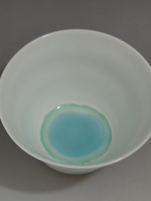 白磁のマットな釉薬の器。内側の底にターコイズ色の釉薬が溜まる、上から