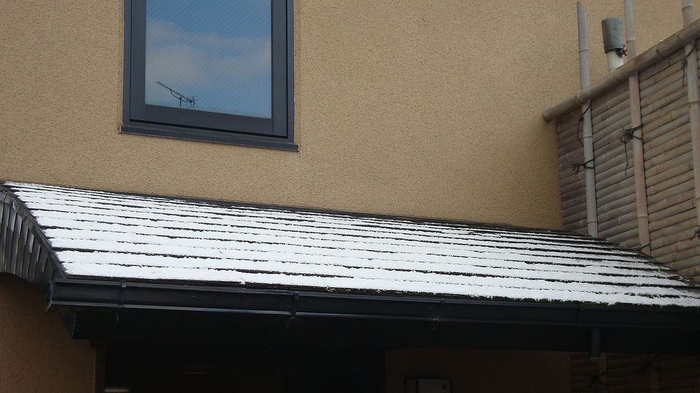 うっすら雪が積もった軒の庇と窓