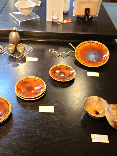 秋らしい飴色の皿や茶碗が展示された和食器のディスプレイ