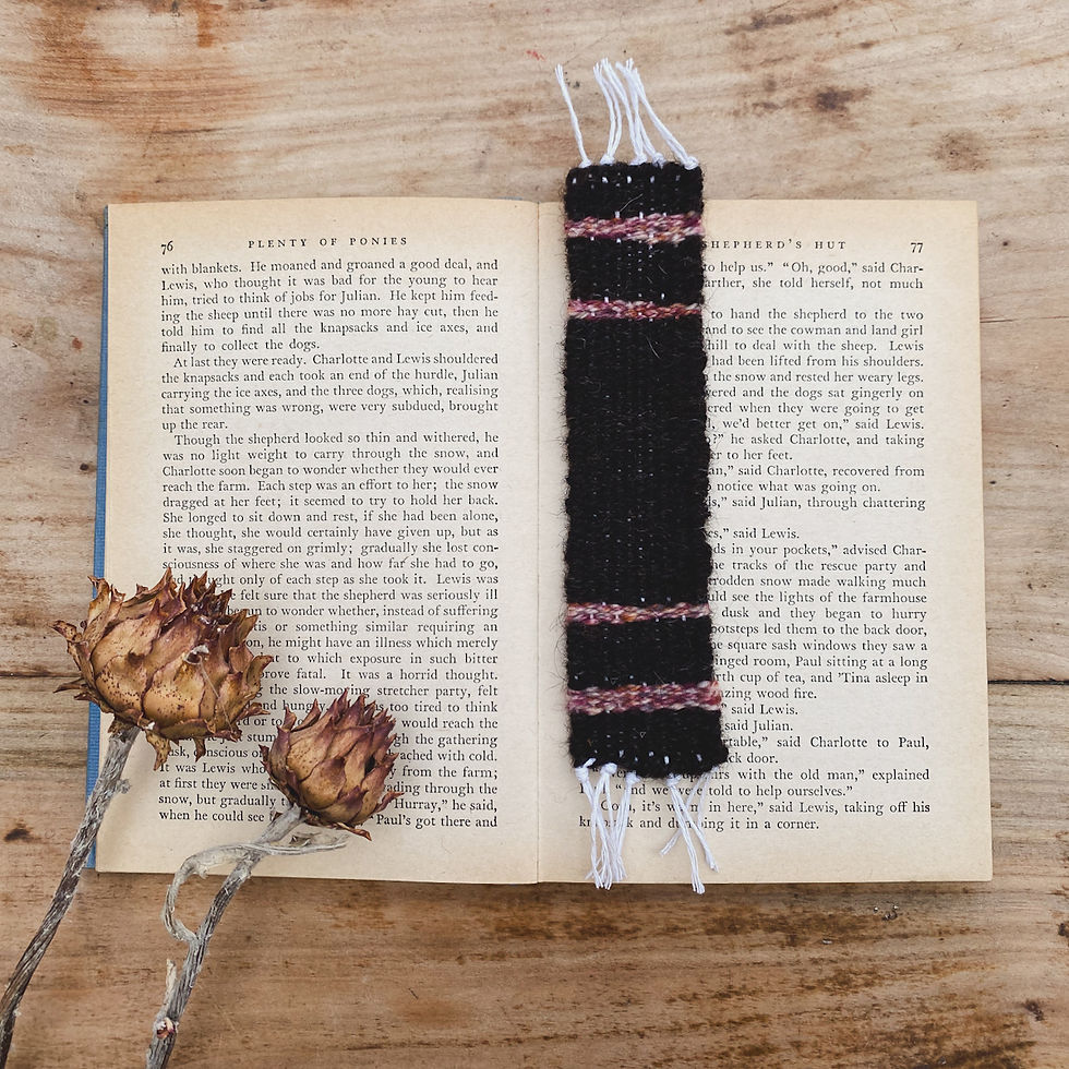 A brown and pink woven bookmark sitting on a book