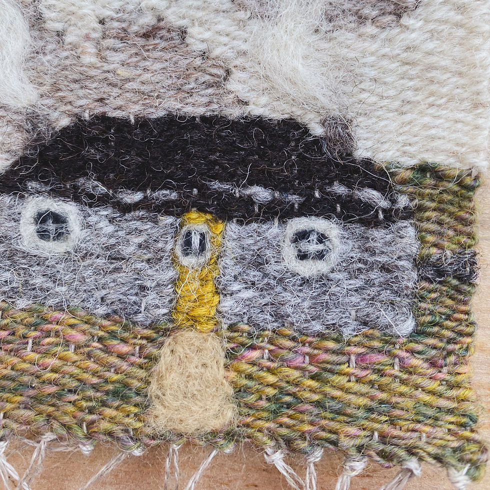 Thumbnail: Close up detail of a handwoven wall hanging featuring a Scottish Cottage