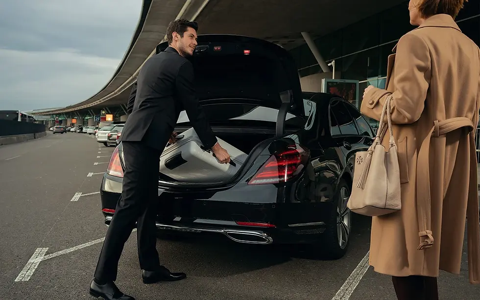 Chauffeur getting client luggage out of trunk of car