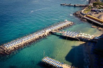 Aerial view of bathing platforms and turquoise Mediterranean water at Marina Grande, Sorrento, Italy