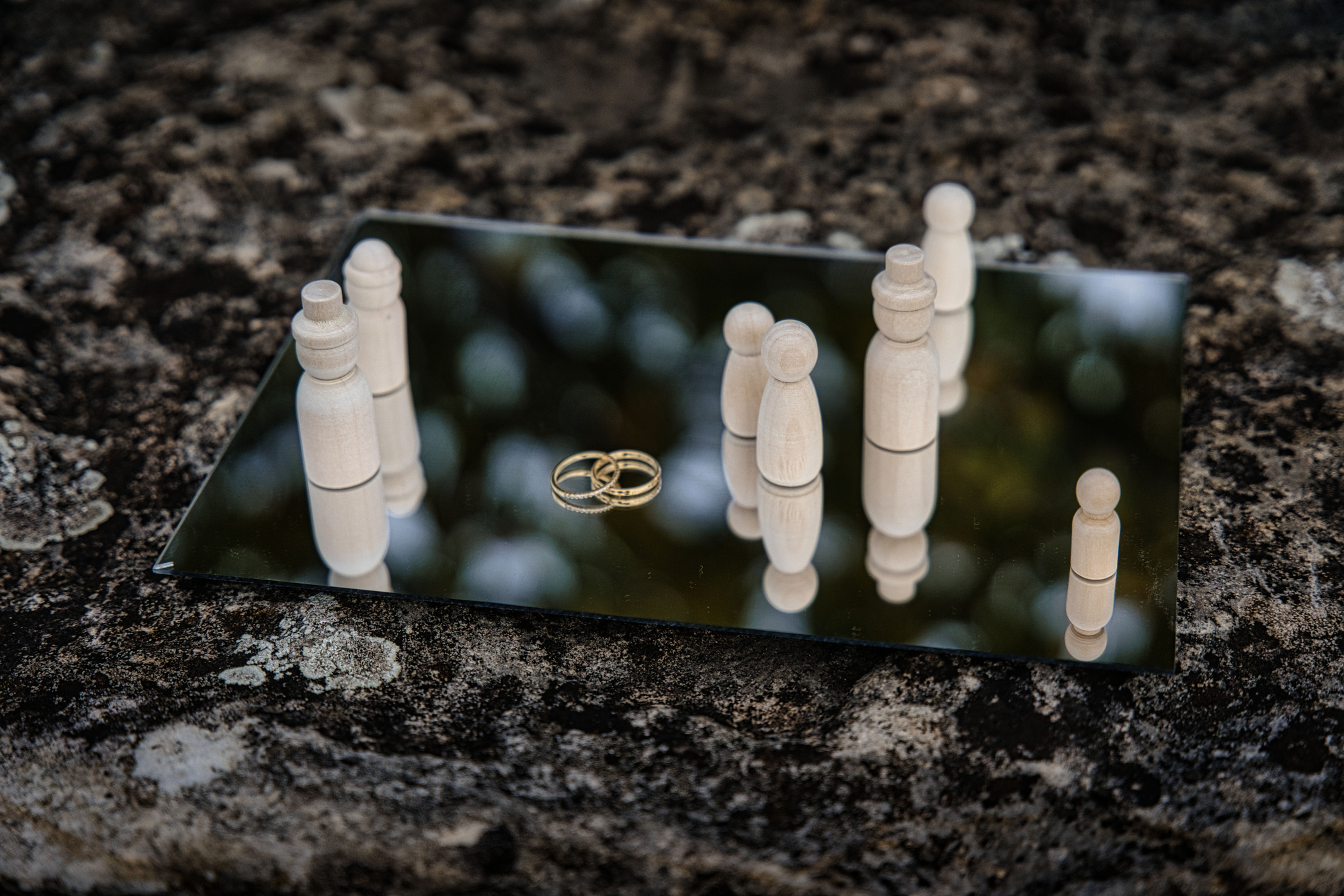 symbolische Aufstellung von Männchen auf einem Spiegel mit zwei Eheringen