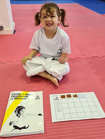 ninja tot sat smiling in a martial arts class