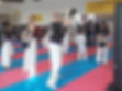 family martial arts class with students wanting to answer a question