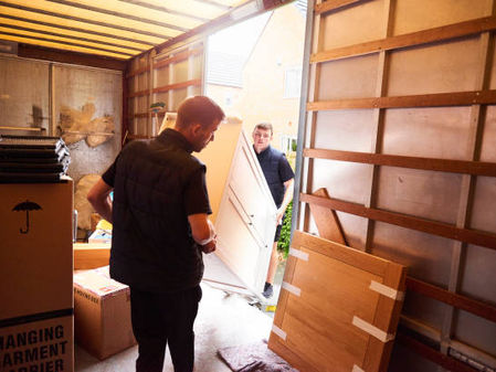 Movers loading furniture and boxes into a moving truck