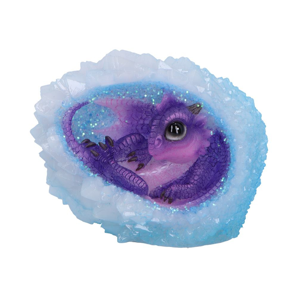 Infuse your space with enchanting radiance using our Geode Nest (Purple) figurine, a captivating creation from Nemesis Now's value collection. This charming purple dragonling, with large and captivating eyes, finds comfort curled up within the protective embrace of a serene blue crystal geode. The crystal is designed to illuminate, (batteries required), casting a serene blue light from the dragonling's heart center. Crafted from the finest resin and hand-painted with meticulous care, this figurine seamlessly combines enchanting style with magical allure. Explore our extensive collection of dragon-themed giftware, perfect for those who have a deep appreciation for magical creatures. Illuminate your room and immerse yourself in the enchantment of this delightful Geode Nest (Purple).