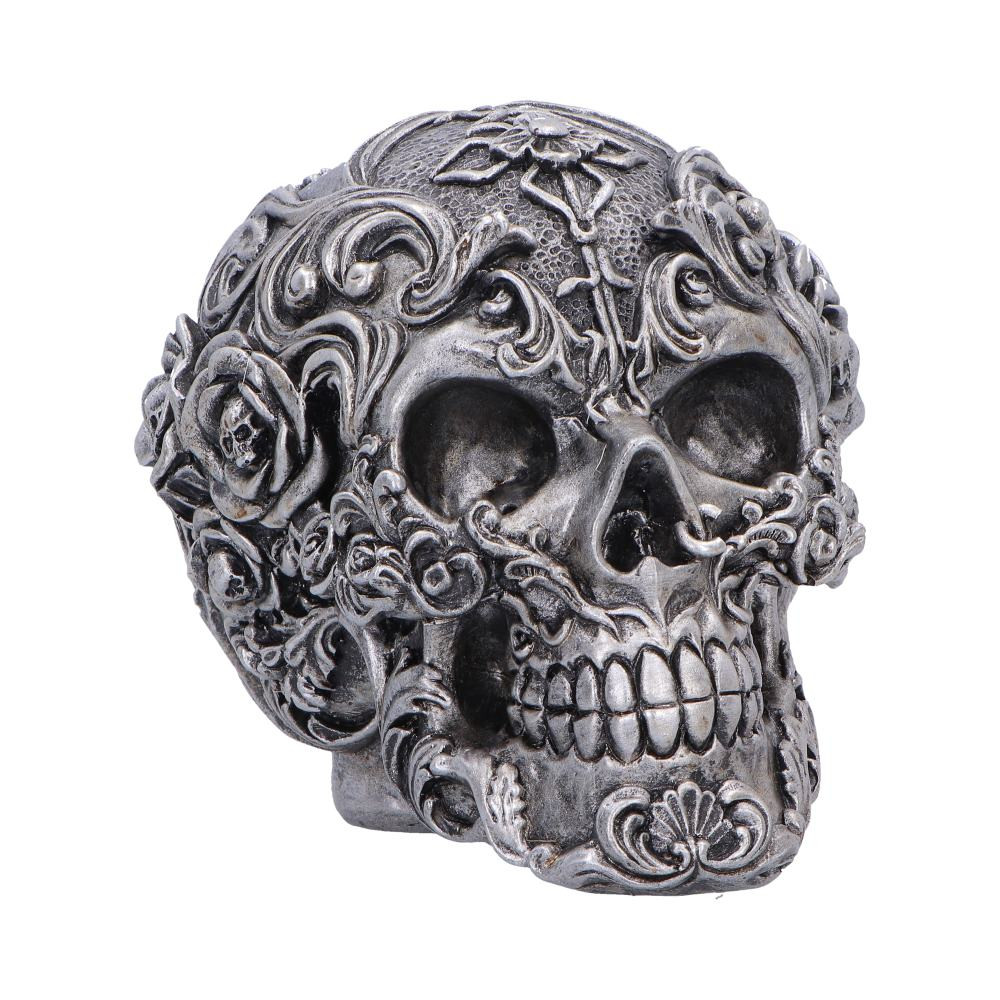 Gilded Memento is a gothic skull figurine originally designed by Nemesis Now, crafted to bring dark elegance to any space. Adorned with intricately sculpted swirls, delicate flowers and tiny skull details, it is cast in high-quality polyresin and hand-painted in a rich dark silver finish to enhance its dramatic aesthetic. Securely packaged in a branded box with protective padding, it’s perfect for gifting or display. Ideal for gothic decor enthusiasts, collectors and lovers of macabre art, this striking piece adds a bold, sophisticated edge to your home.