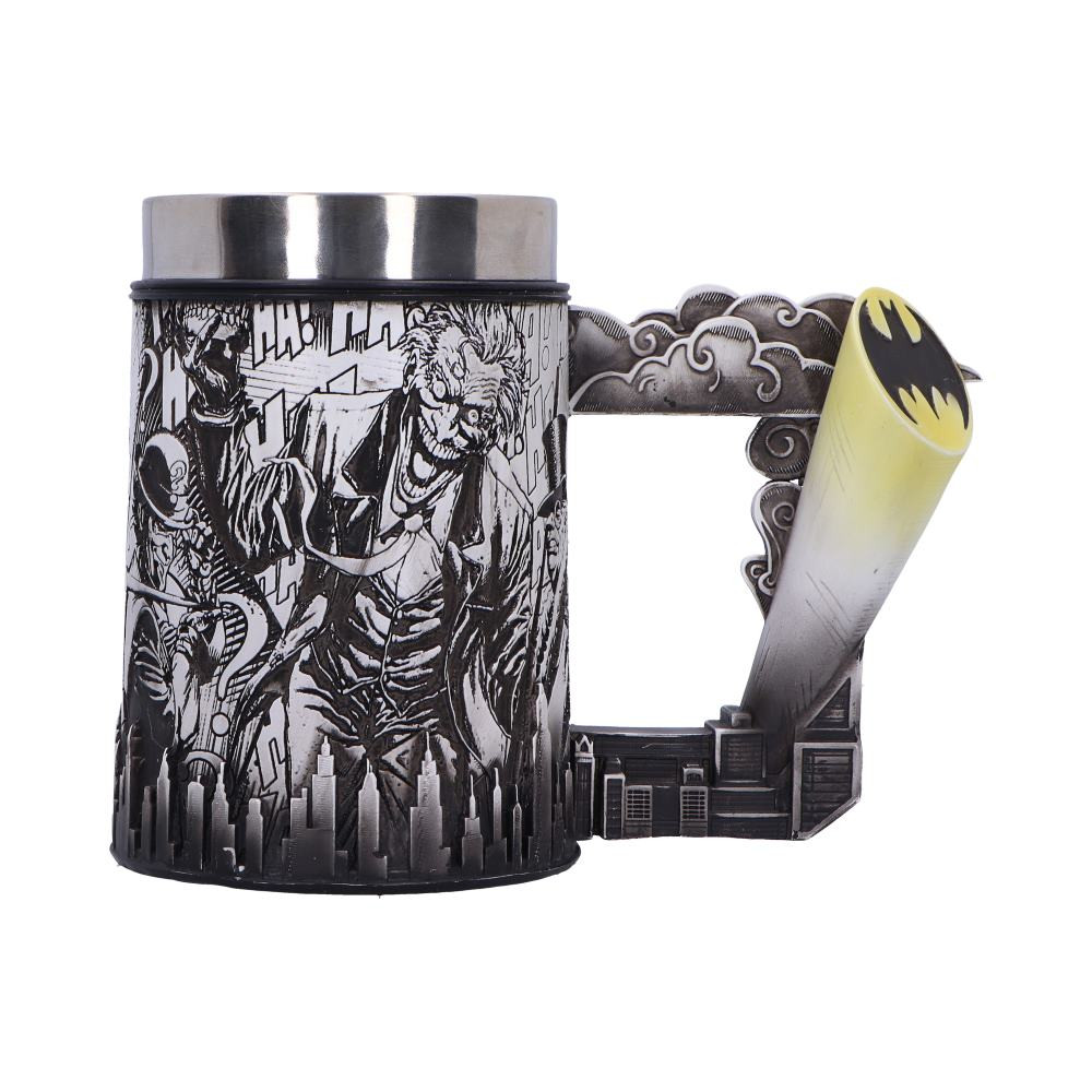 Embrace the dark and gritty world of Gotham with the Officially Licensed DC Batman Super Villain Comic Strip Collectible Tankard. This functional piece features a striking wraparound design that brings iconic Batman comic strip scenes to life. From Gotham's rooftops to intense face-offs with notorious villains, each panel tells a story of The Dark Knight's relentless pursuit of justice. Designed with a stainless steel insert for easy cleaning, this tankard is perfect for both display and use. Packaged in a Nemesis Now and DC Batman branded gift box, it makes an ideal addition to any collection or a thoughtful gift for fans of the DC and Batman universe. Let the legend of Batman grace your collection with this Comic Strip Tankard.