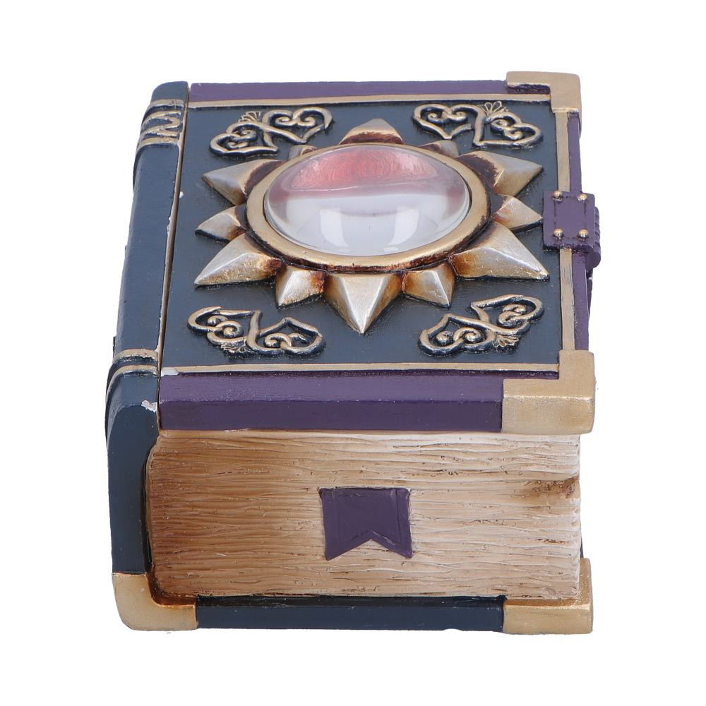 The Watchers Wealth Box, originally designed by Nemesis Now, is a compact fantasy trinket box styled to resemble an aged magical book. Measuring approximately 6.4cm tall and 12.7cm wide, it features a removable lid and intricate fantasy detailing, including black and purple colouring, spiked and swirling accents, aged pages and decorative buckle and a striking red eye set atop the lid. Cast in high-quality resin and hand-painted, this unique piece is carefully packaged to protect its detailed finish. Ideal for fantasy enthusiasts, collectors of mystical decor and anyone who enjoys magical themed ornaments, the Watchers Wealth box offers a distinctive and enchanting way to store your small treasures