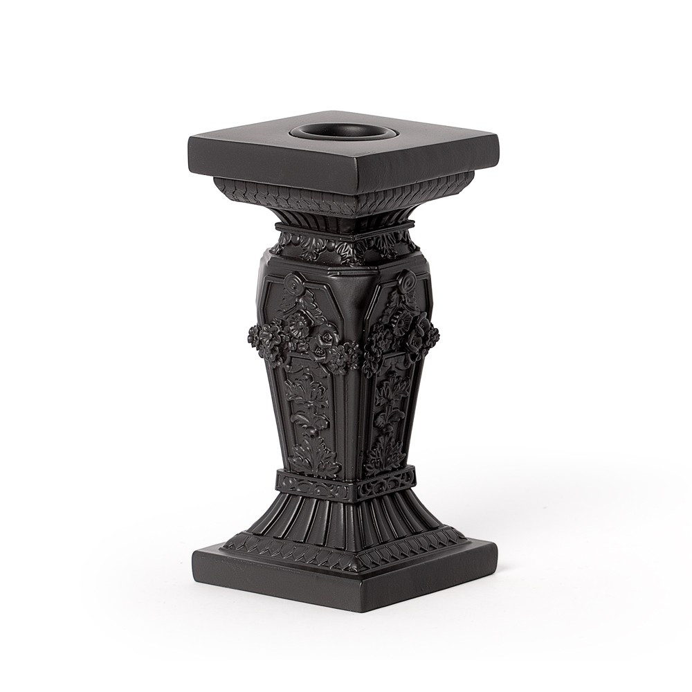 A gothic tomb-inspired candlestick with architectural detailing reminiscent of ancient mausoleums and forgotten cathedrals. Designed to hold a taper candle, its structured form and dark finish create a solemn, atmospheric presence. Crafted from resin, this piece is perfect for altars, gothic interiors, or those drawn to the romance of mortality and memory. • A gothic candlestick inspired by tomb architecture • Designed to hold a single taper candle • Structured, cathedral-like detailing for dramatic styling • Ideal for altars, gothic decor, or atmospheric lighting • Durable resin construction with dark antique finish • Evokes themes of memory, mystery, and timeless romance Colour: Black