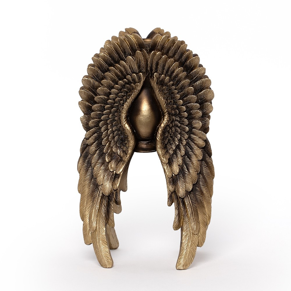 A striking angel wing candle holder, sculpted to form a protective embrace around a single candle. The layered feather detailing gives depth and movement, creating a dramatic gothic centrepiece. Finished in antique gold tones, this resin candle holder brings a sense of celestial mystery and melancholic beauty to any setting. Ideal for gothic home decor, altar styling, or romantic interiors • Decorative angel wing candle holder with layered feather detailing • Holds a single candle within a protective winged form • Antique gold finish adds celestial gothic elegance • Perfect for altars, gothic decor, or romantic interiors • Lightweight yet detailed resin construction • A symbolic piece blending beauty, protection, and mystery Colour: Antique Gold