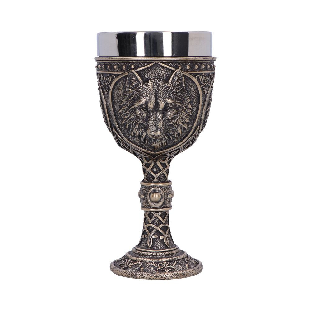 Immerse yourself in the mystical allure of the Wild Thirst Chalice, a captivating creation from Nemesis Now's value collection. This bronze-colored chalice, featuring a stainless steel insert, is not just a vessel but a testament to the wild elegance of the wolf. Multiple wolf heads adorn the chalice within ornate crests, each detail meticulously crafted to capture the spirit of these majestic creatures. The stem of the chalice is adorned with intricate knot detailing, and at its center lies a yellow ring with a captivating yellow gemstone, adding an extra layer of enchantment to the design. The base of the chalice mirrors the ornate detailing found throughout, creating a seamless and harmonious aesthetic. Crafted from the finest resin and hand-painted with precision, the Wild Thirst Chalice is a masterpiece that embodies the essence of magical creatures. Part of Nemesis Now's extensive wolf-themed giftware collection, this chalice is tailored for those who have a deep appreciation for the mystical and powerful symbolism of wolves. Whether your customers are collectors or seeking a unique gift, the Wild Thirst Chalice is a timeless and bewitching addition to any fantasy enthusiast's collection.
