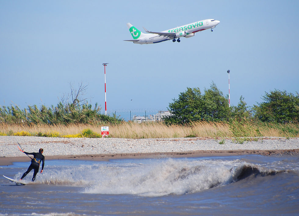 Le F-GZHQ de Transavia s'élève au dessus de la Méditerranée sous le regard d'un wind surfer