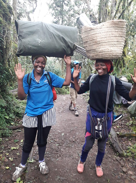 2 female Porter on Kilimanjaro carrying heavy loads on their heads