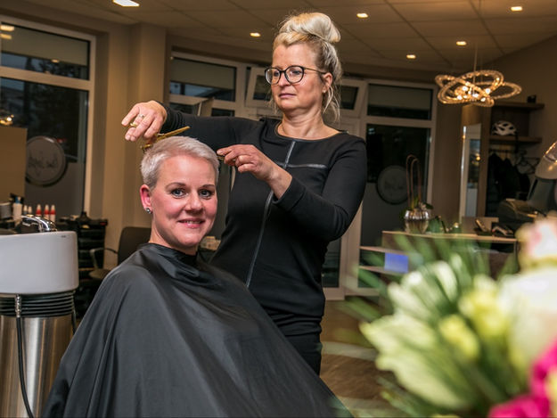 Friseurin schneidet einen Damenhaarschnitt
