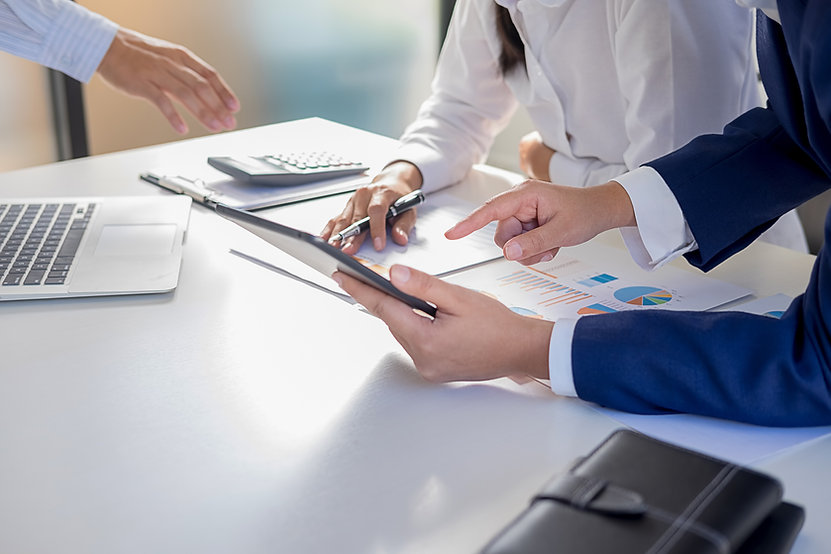 Businesswoman and attorney reviewing business law paperwork at a table.