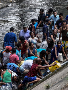 Venezolanos recogen agua en río contaminado tras escasez por apagón