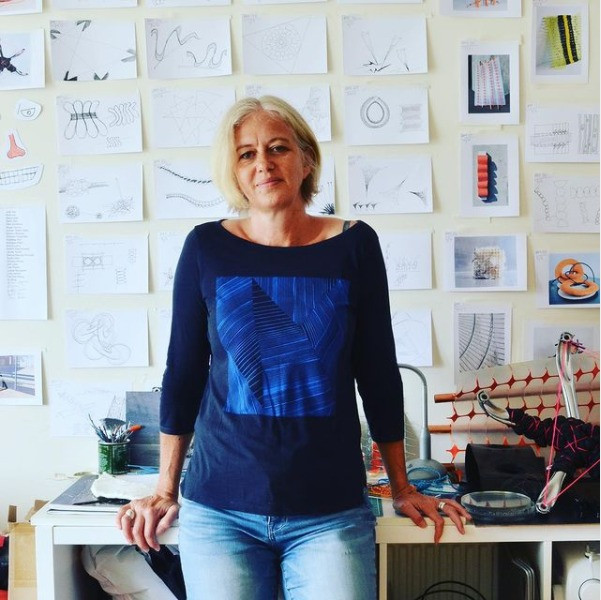 Sam Haynes, public artist and found art sculptor, standing in her art studio