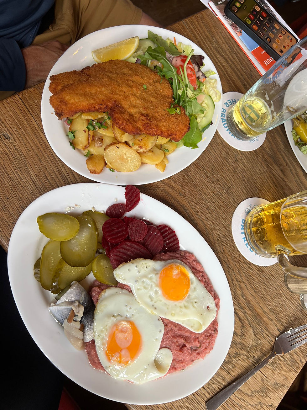Bob went classic with schnitzel. I tried Labskaus—a Northern German dish linked to Hamburg’s seafaring past. It’s mashed potatoes, corned beef, onions, and beetroot (which turns it pink), topped with fried eggs and served with pickled herring, pickles, and beets. I’m glad I tried it…but once is enough.