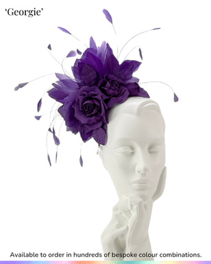 Feathered headpiece or fascinator, featuring a spray of silk roses in a 'shot' purple silk, being shown on a studio mannequin.
