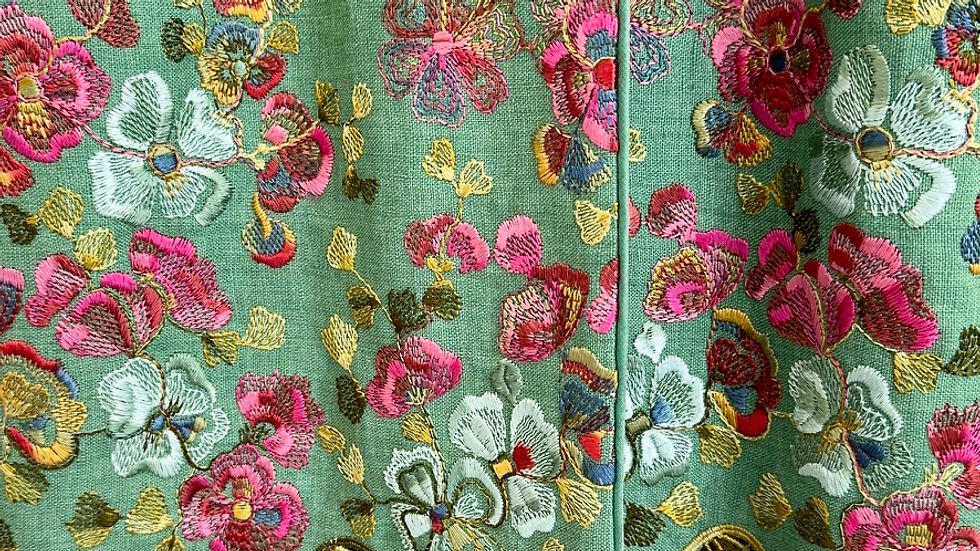 Detailed image of a spring-green embroidered linen coat from Favourbrook Womenswear.