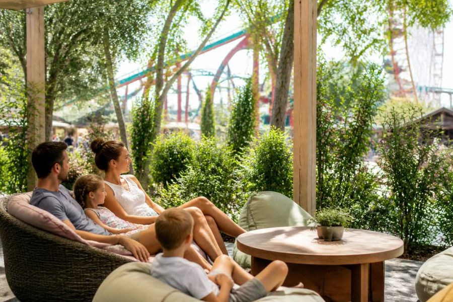 Eine Familie entspannt sich in einer abgeschirmten Ruhezone im Freizeitpark für mehr Ruhe und emotionale Sicherheit.
