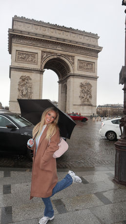 A picture of Halle in front of the Arc de Triomphe in Paris, France