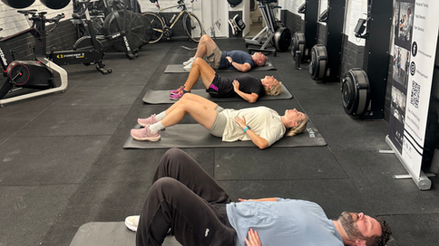 Athena members laying down on.exercise mats, practicing breathwork and breathing exercises.