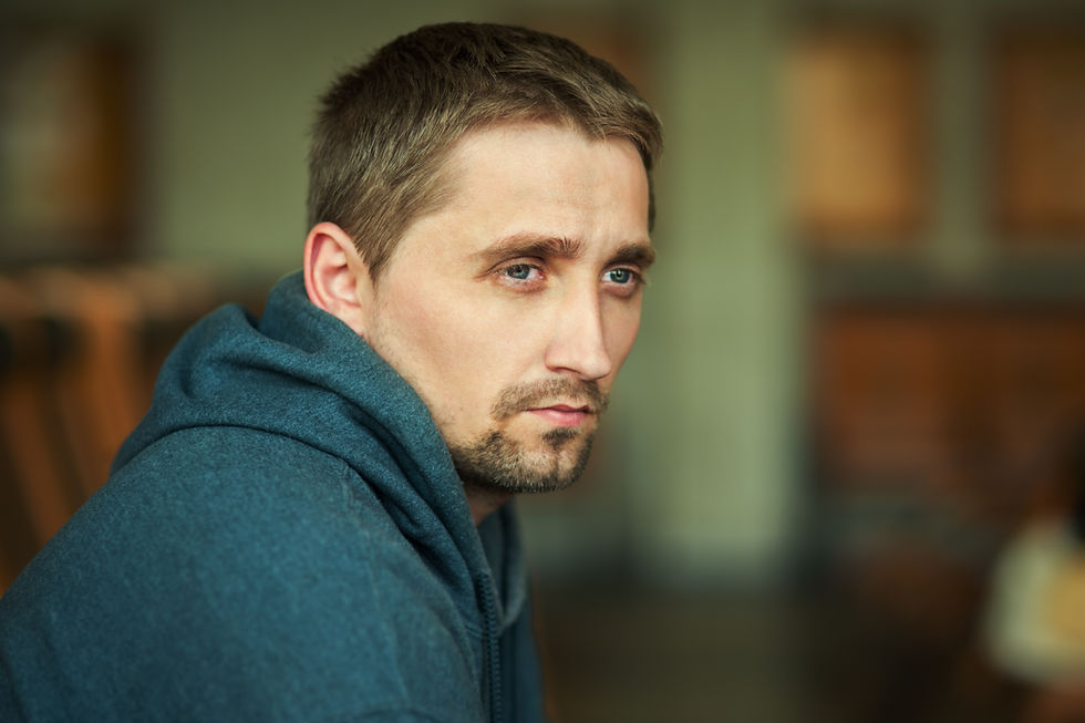 Stock photo of a man looking thoughtful staring out into the distance.