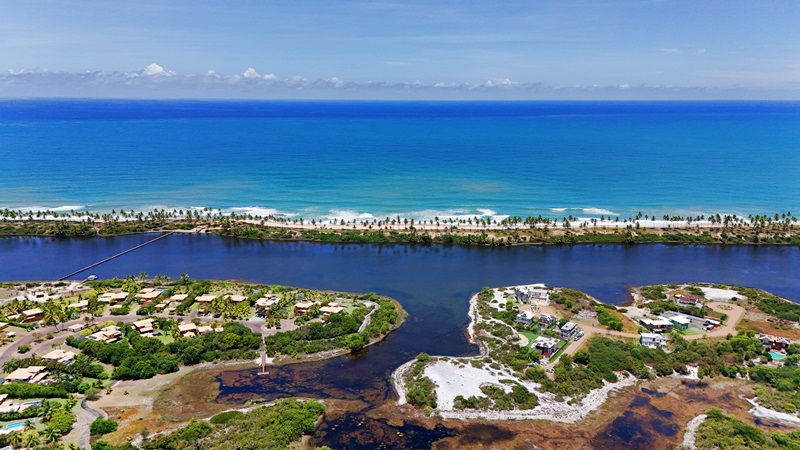 Paisagem surreal composta por lagoa, coqueirais e mar na Costa do Sauípe