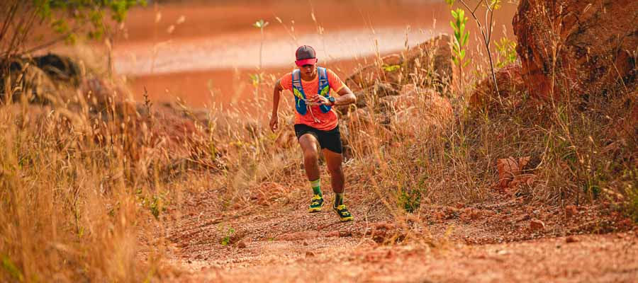 maratonista de camisa laranja paisagem seca ultra trail chapada