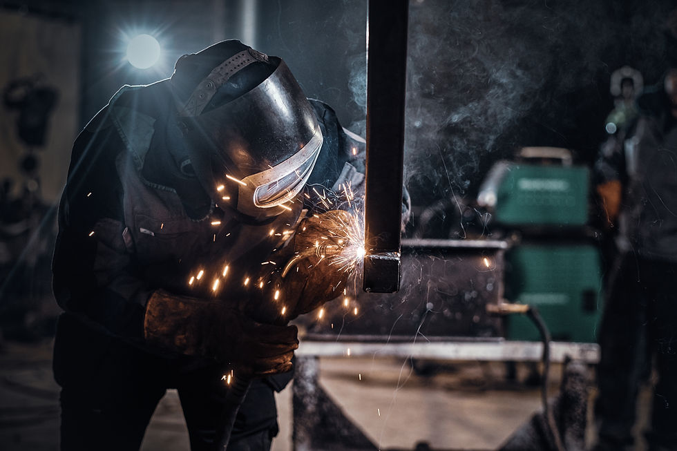 Professional welder working on metal fabrication project with sparks flying