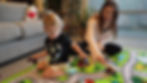 Child sitting on a Playtime Rug memory foam tatami mat in a playroom