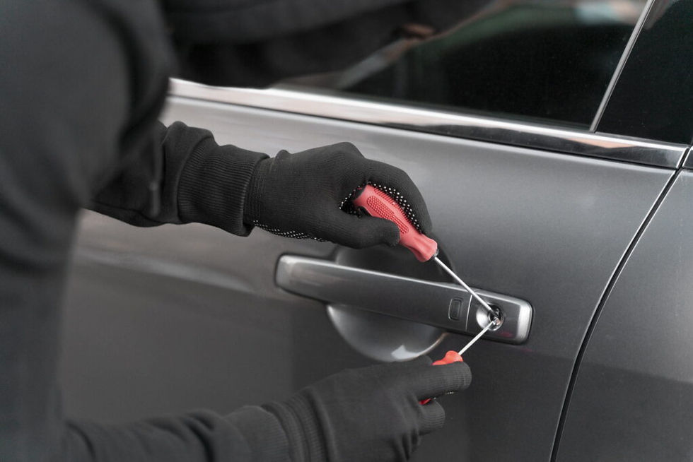 Gloved hands picking a car lock