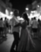 Couple holding hands and smiling at each other on a crowded street at night