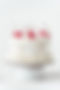 Delicate lambeth style birthday cake with white cream cheese frosting decorated with cockt