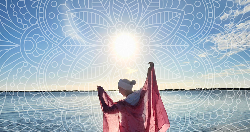 Kundalini Yoga teacher with a pink cloth, backlight by the sun on the beach with a mandala pattern on top of it
