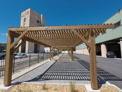 Vue en enfilade de trois carport séparés pour ombrager les places de parking.