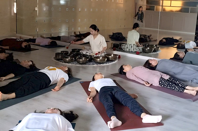 다사요가 정홍숙 원장이 회원들에게 싱잉볼 연주를 해주는 모습