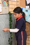 CHILD DRAWING ON CHALKBOARD