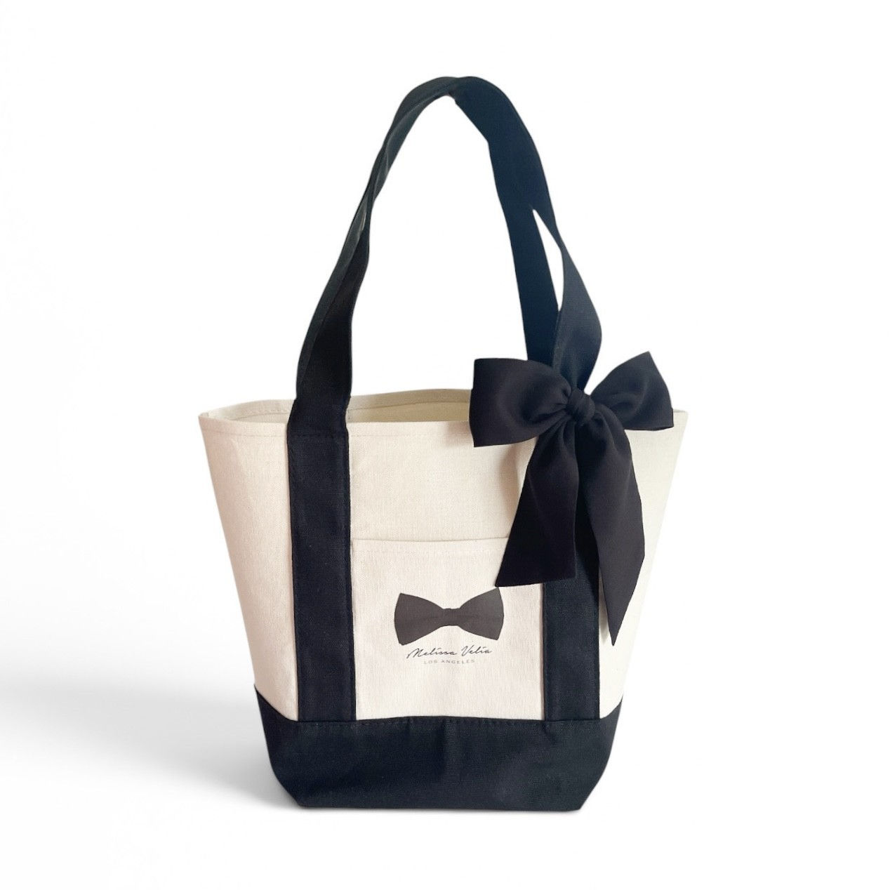 signature Mini Market Bag comes with a detachable ribbon bow and a cute front pocket. It also comes with a black zippered bag